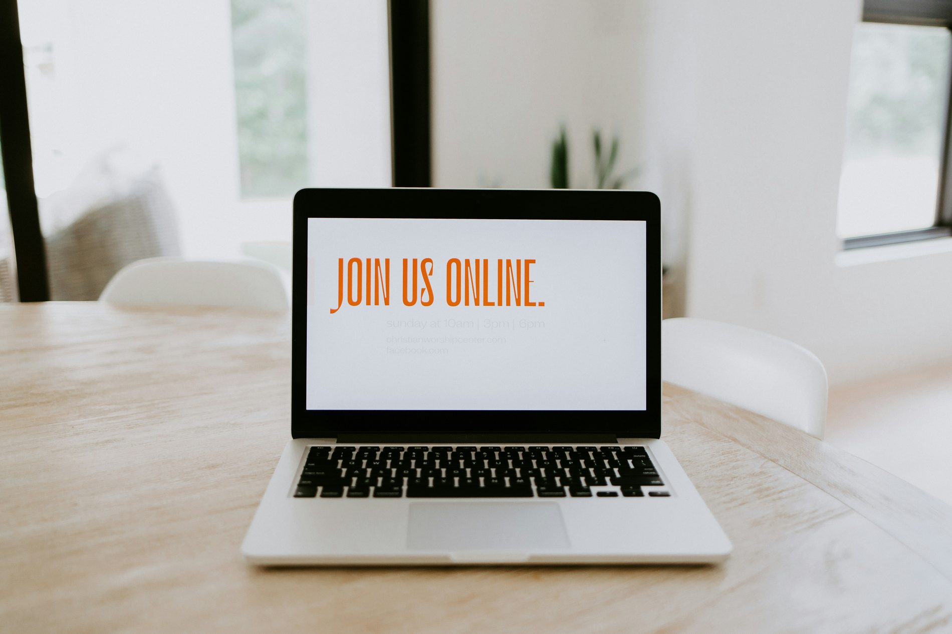 Laptop op een lichte tafel met de tekst Join us online op het scherm