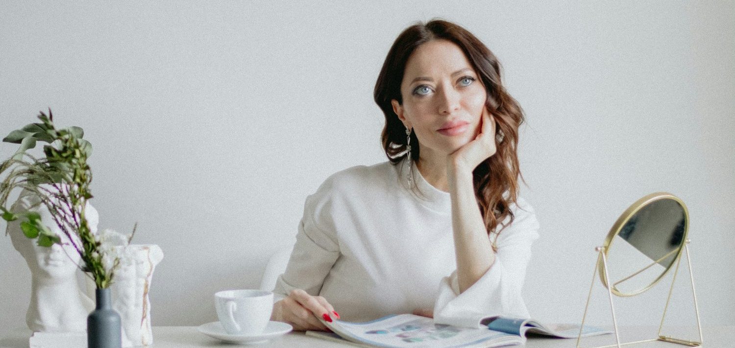 Beauty-ondernemer zit peinzend aan haar bureau en denkt na over de koers van haar zaak