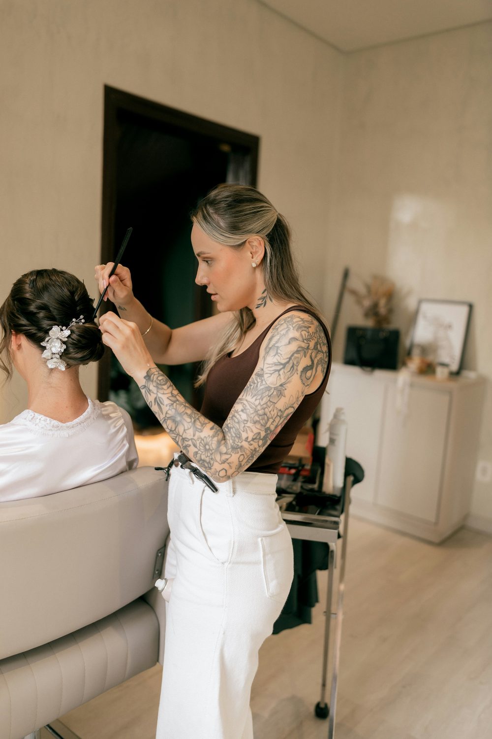 Beauty-professional werkt aan een opgestoken kapsel bij een klant in de salon