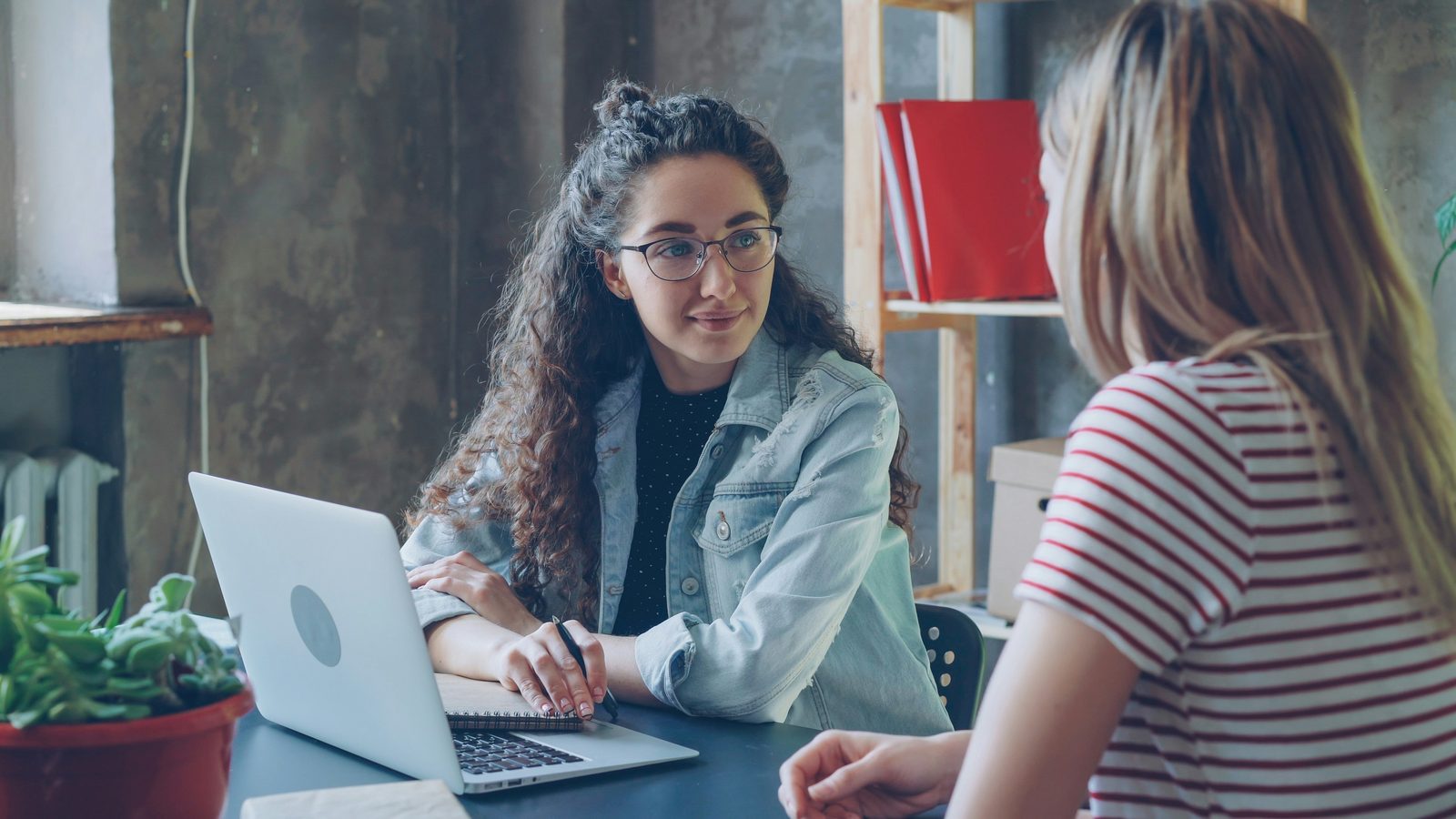 Twee vrouwen bespreken samen een financieel plan achter een laptop