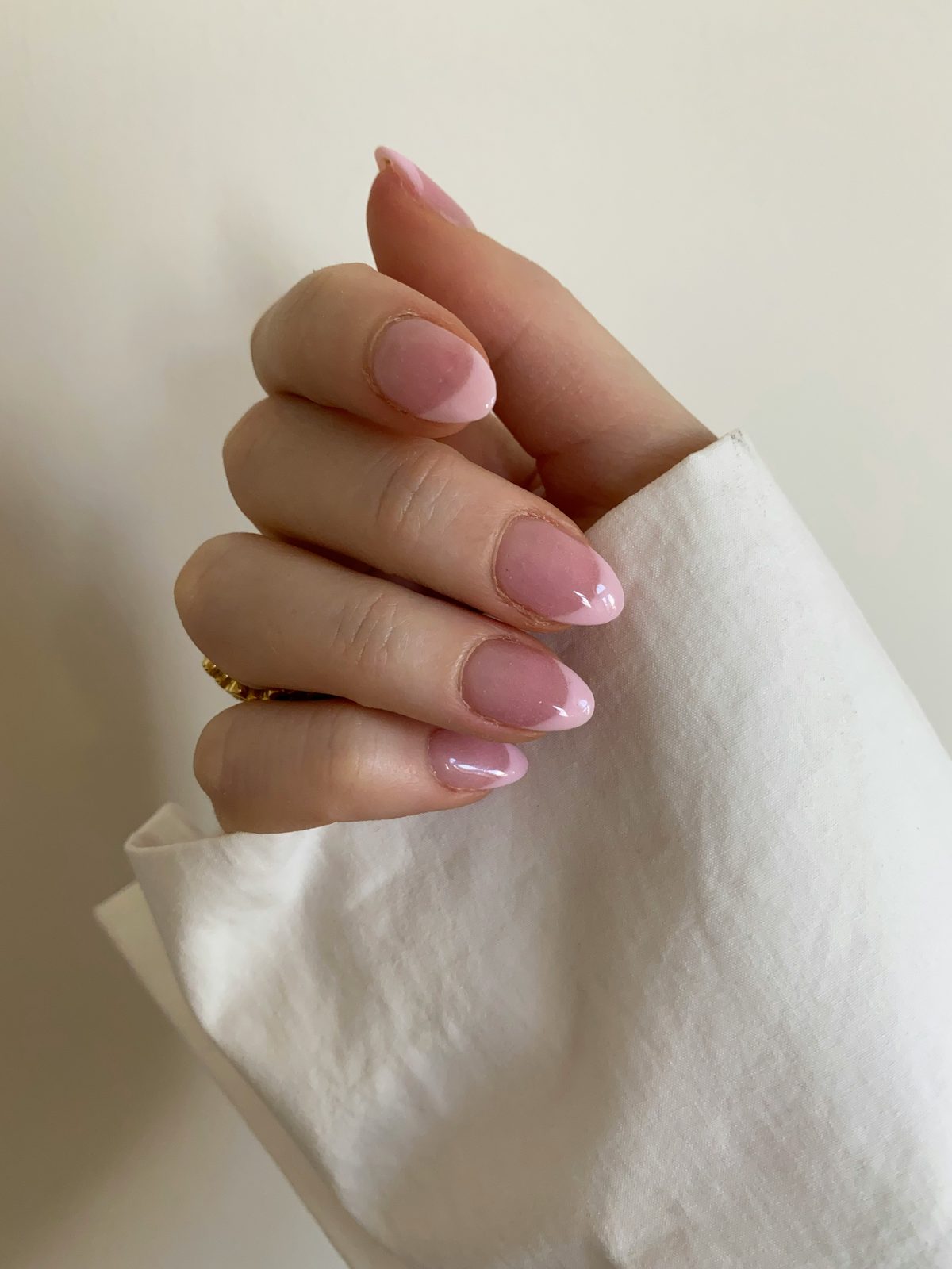 Korte amandelvormige nagels in zacht roze met een glanzende, glasachtige finish