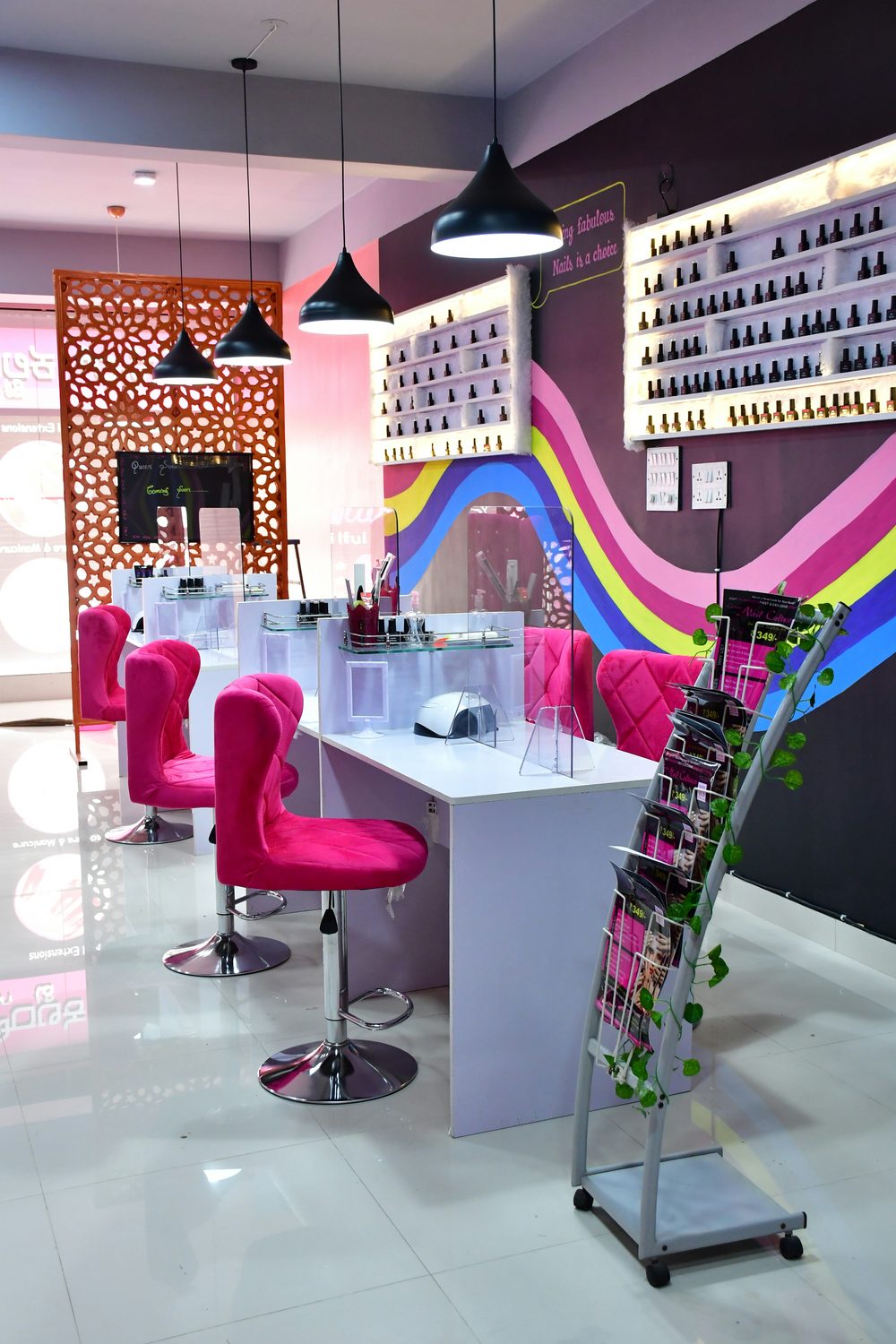 Ingerichte nagelstudio met een strakke werktafel, comfortabele stoelen en een verlichte wand met nagellak