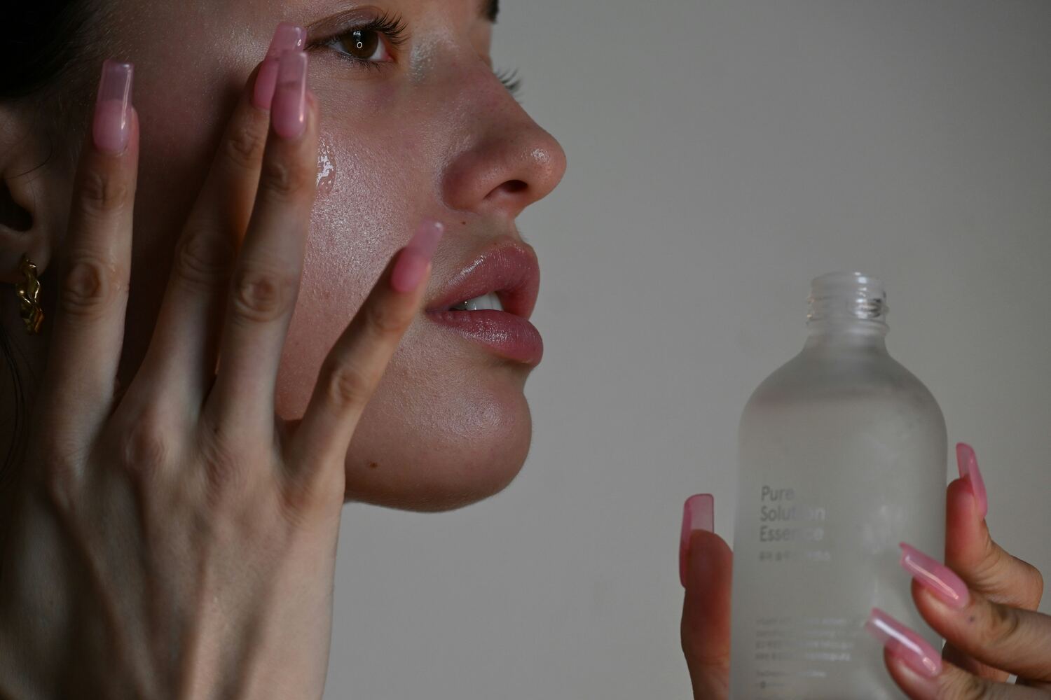 Close-up van het aanbrengen van een hydraterend serum voor een stralende huid