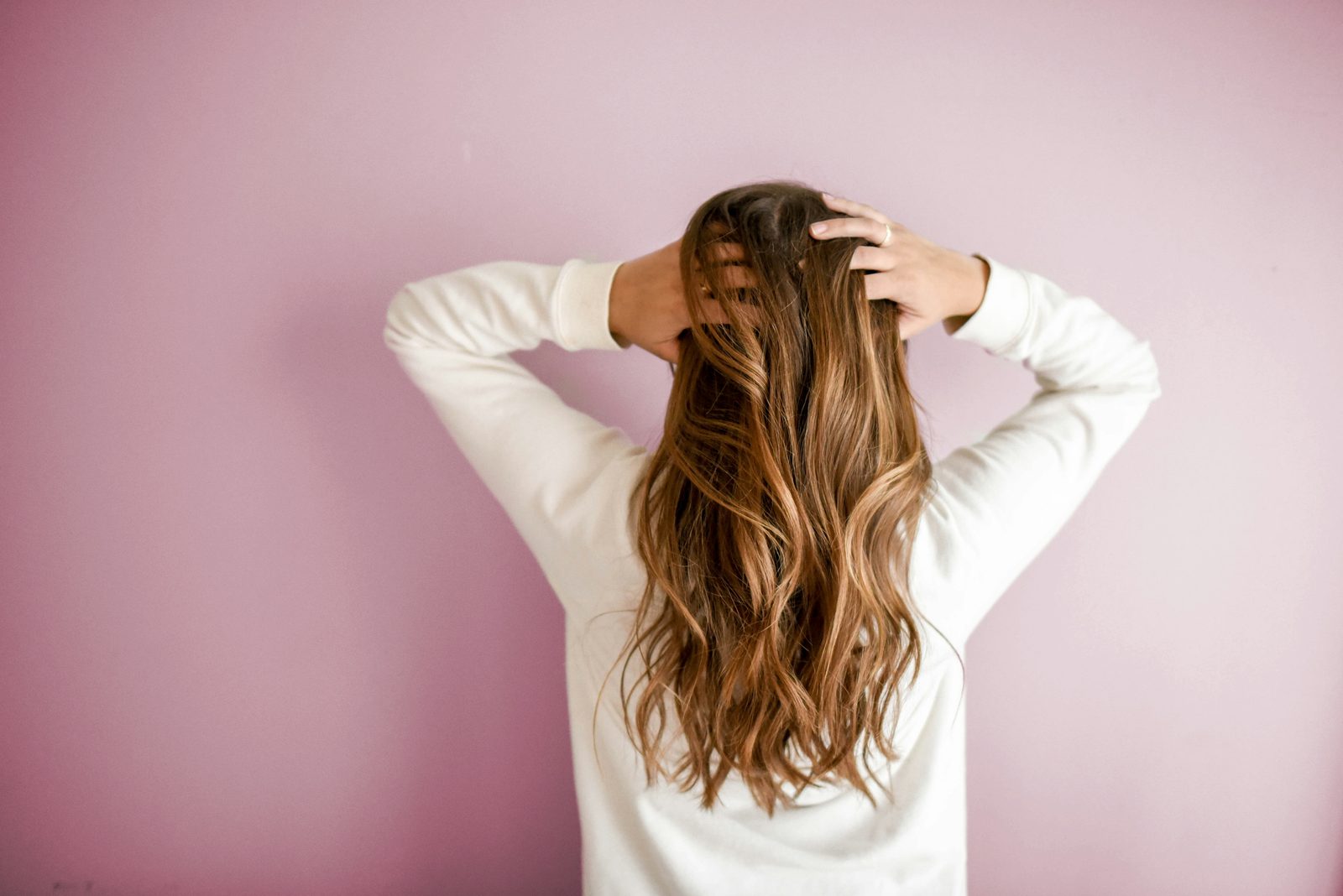 Kapster krult het haar van een klant tijdens een styling in de salon