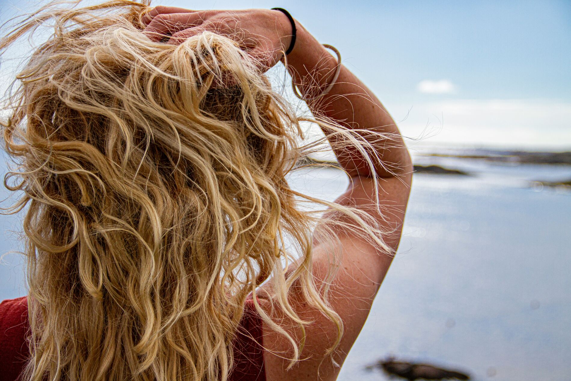 Close-up van winderig, golvend haar aan het strand